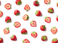 A collection of whole and chopped strawberries
