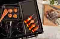 A hob and burner with skewers being cooked